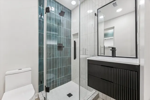 a bathroom with a sink a toilet and shower