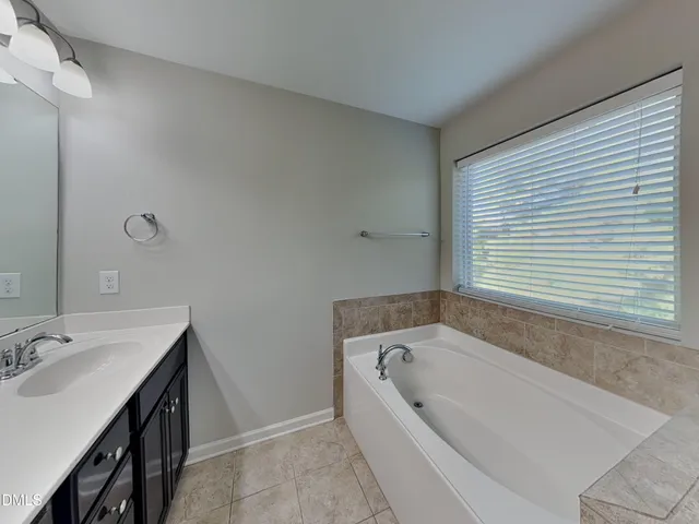 a bathroom with bathtub and window