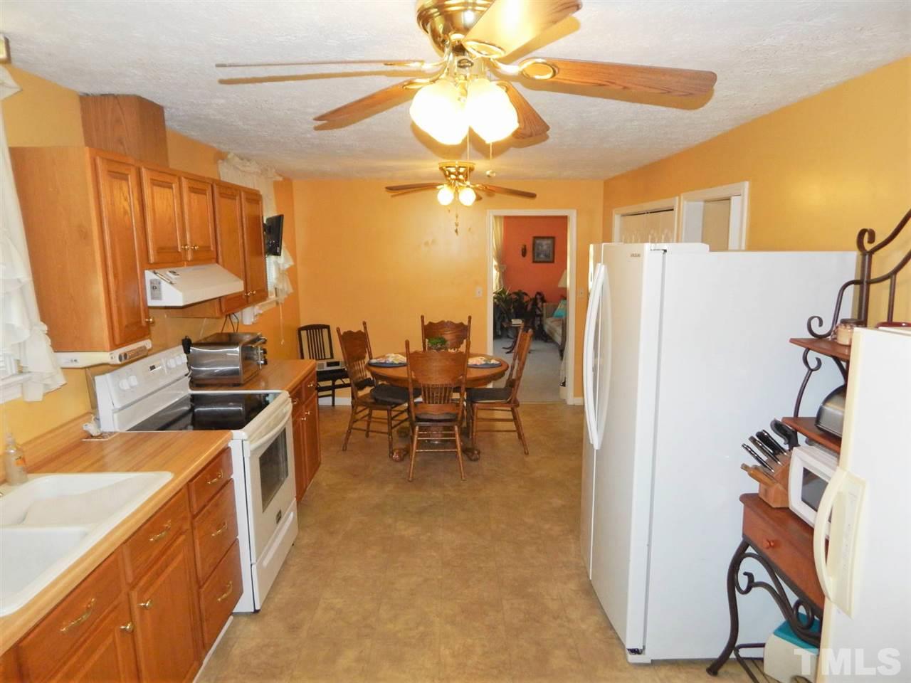 218 John Street Roxboro, NC 27573 - Photo 8 of 25 a kitchen with stainless steel appliances granite countertop a refrigerator a sink a stove and a dining table