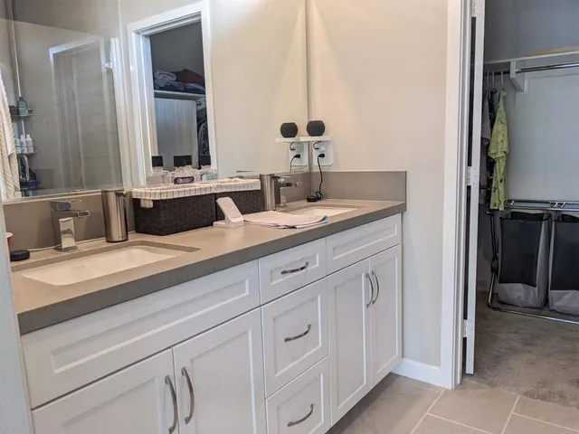 a spacious bathroom with a granite countertop sink and a mirror