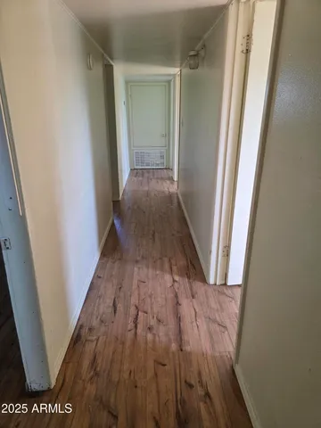 a view of a hallway with wooden floor