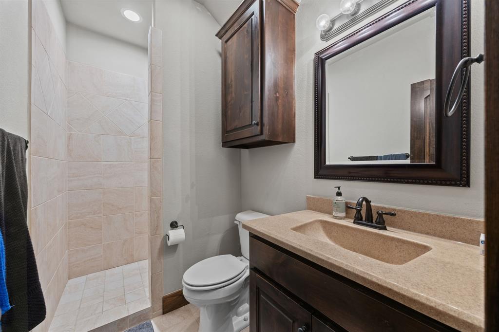 13688 Jackson Road Ponder, TX 76259 - Photo 14 of 20 a bathroom with a granite countertop sink toilet and mirror
