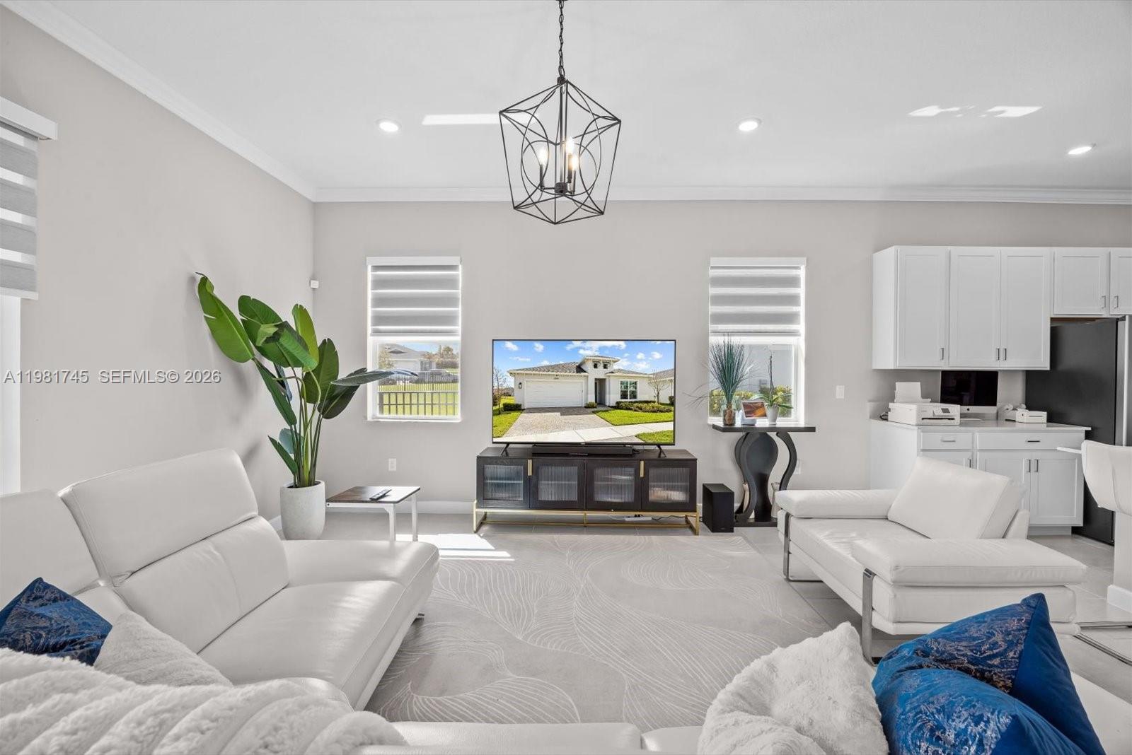 1204 Southeast Woodbine Road Port St. Lucie, FL 34984 - Photo 16 of 46 a living room with furniture a dining table and a chandelier