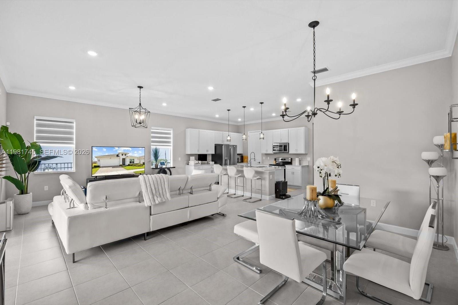 1204 Southeast Woodbine Road Port St. Lucie, FL 34984 - Photo 18 of 46 a living room with furniture and a chandelier