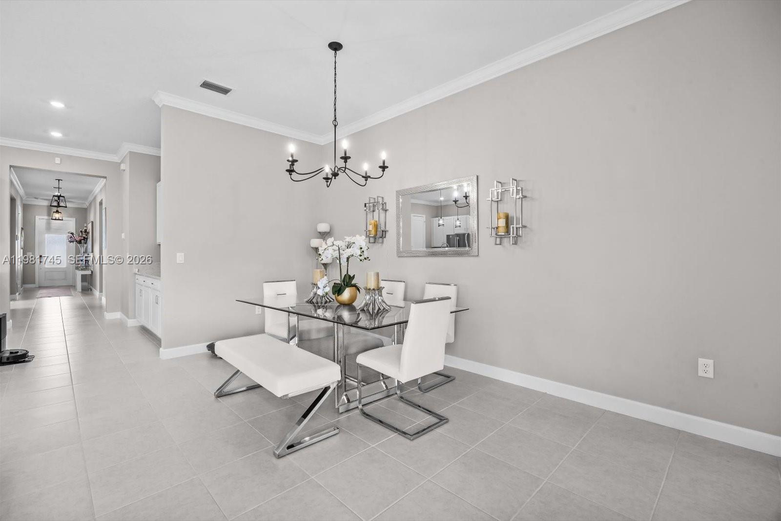 1204 Southeast Woodbine Road Port St. Lucie, FL 34984 - Photo 19 of 46 a view of a dining room with furniture and chandelier