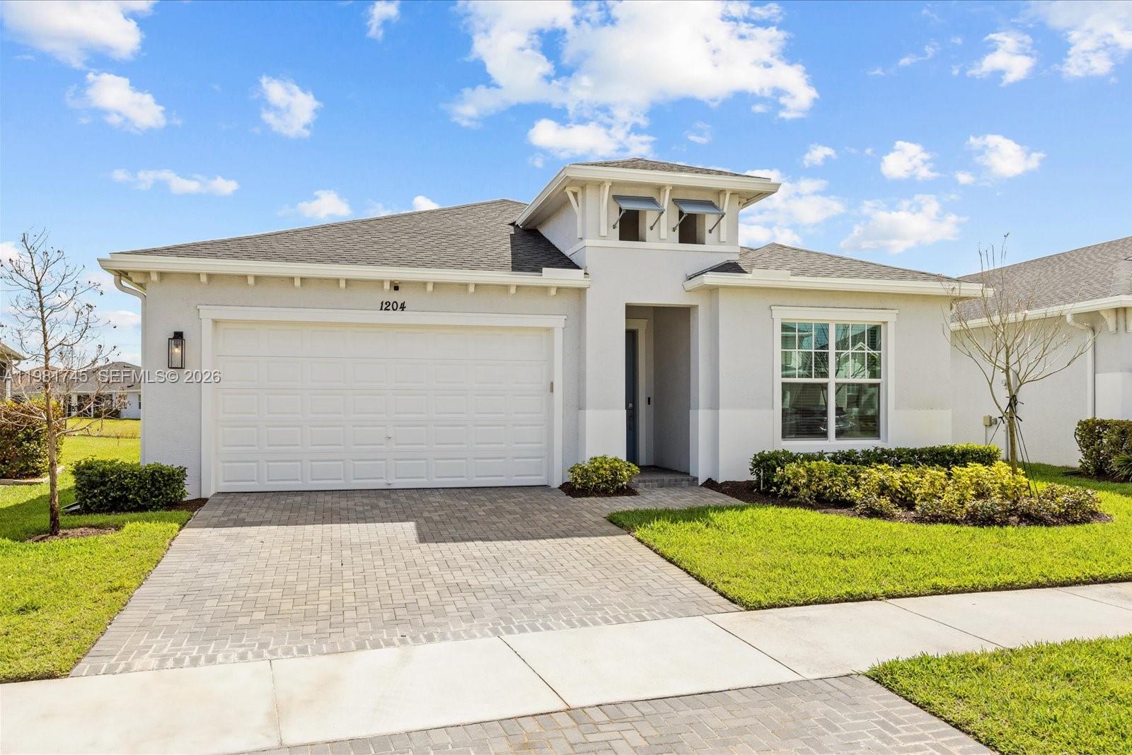 1204 Southeast Woodbine Road Port St. Lucie, FL 34984 - Photo 2 of 46 a front view of a house with a yard