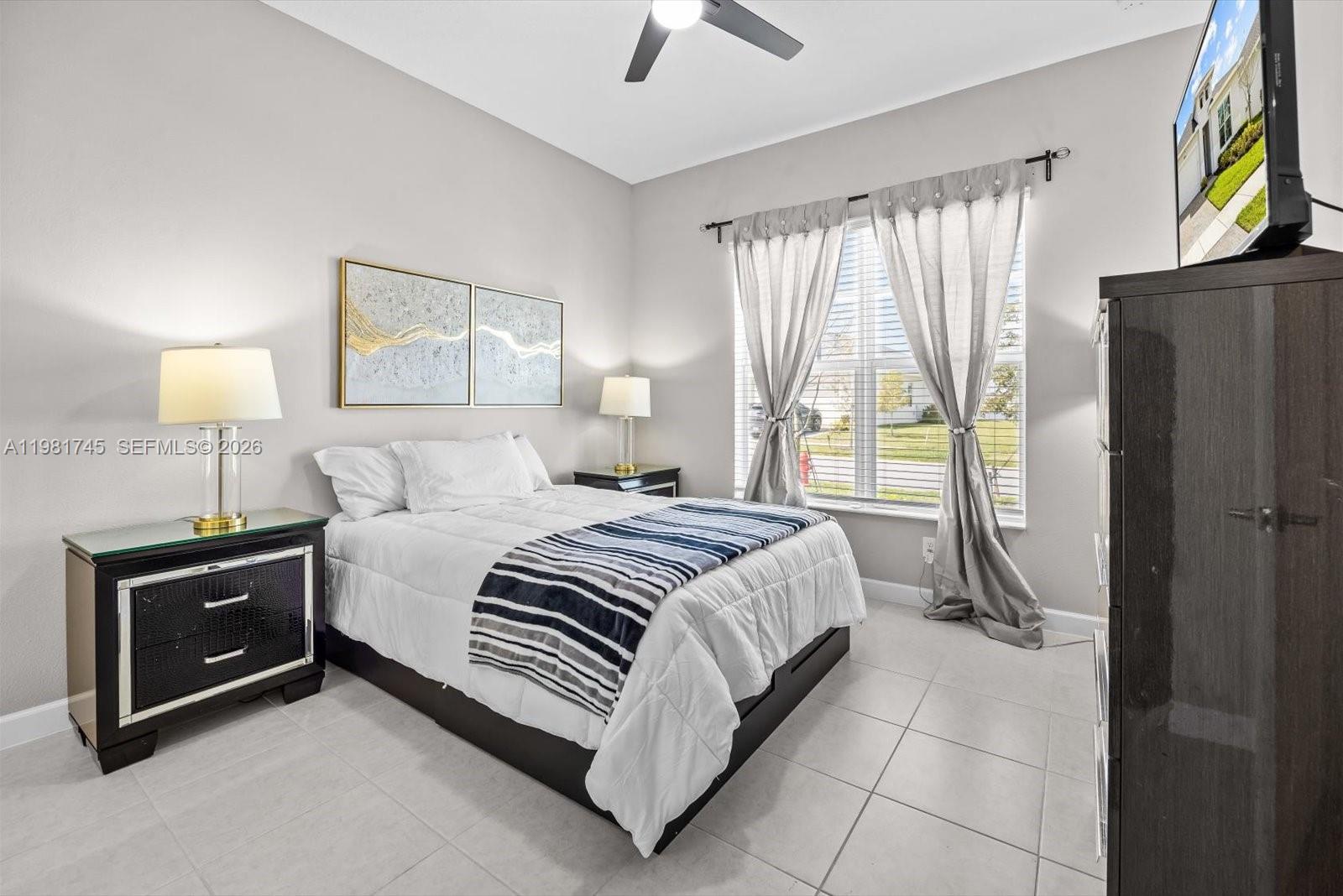 1204 Southeast Woodbine Road Port St. Lucie, FL 34984 - Photo 27 of 46 a bedroom with a bed lamp and a window