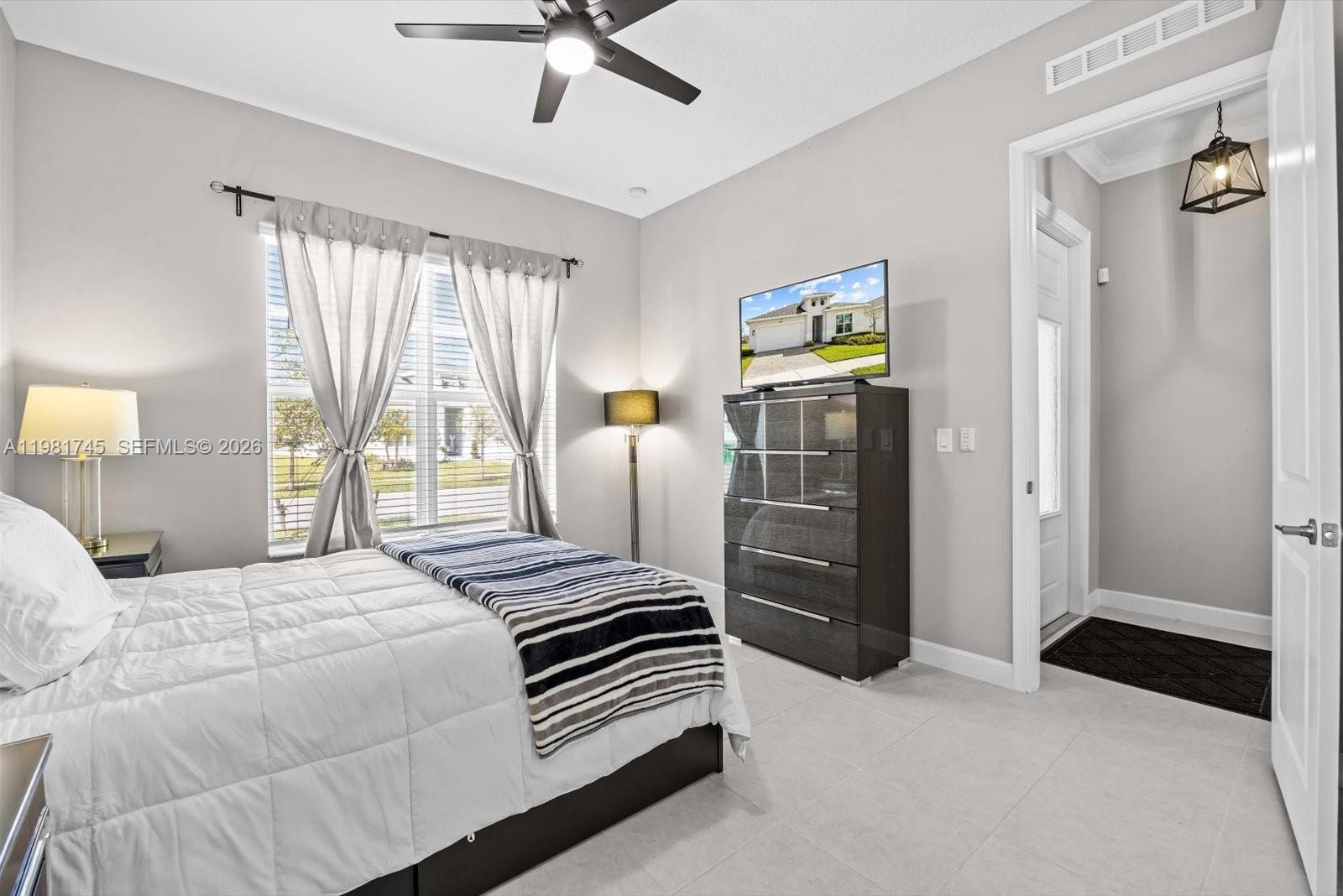 1204 Southeast Woodbine Road Port St. Lucie, FL 34984 - Photo 28 of 46 a bedroom with a bed and a chandelier