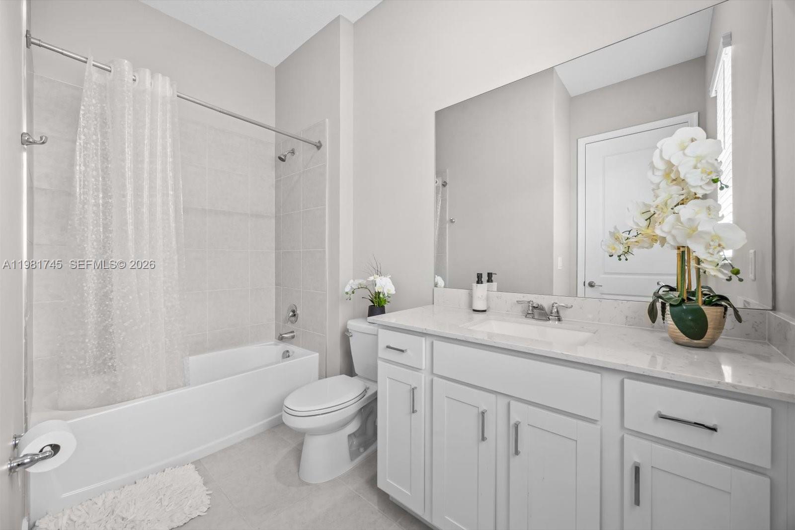 1204 Southeast Woodbine Road Port St. Lucie, FL 34984 - Photo 31 of 46 a bathroom with a granite countertop sink a toilet and a bathtub