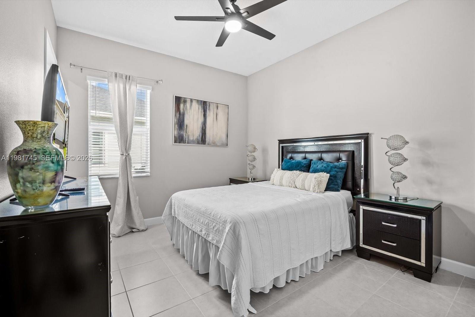 1204 Southeast Woodbine Road Port St. Lucie, FL 34984 - Photo 32 of 46 a bedroom with a bed and ceiling fan