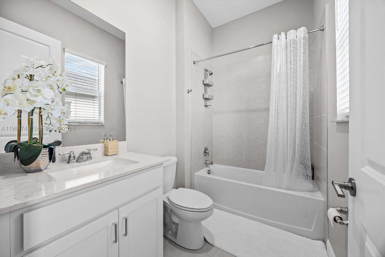 1204 Southeast Woodbine Road Port St. Lucie, FL 34984 - Photo 34 of 46 a bathroom with a sink a toilet and shower