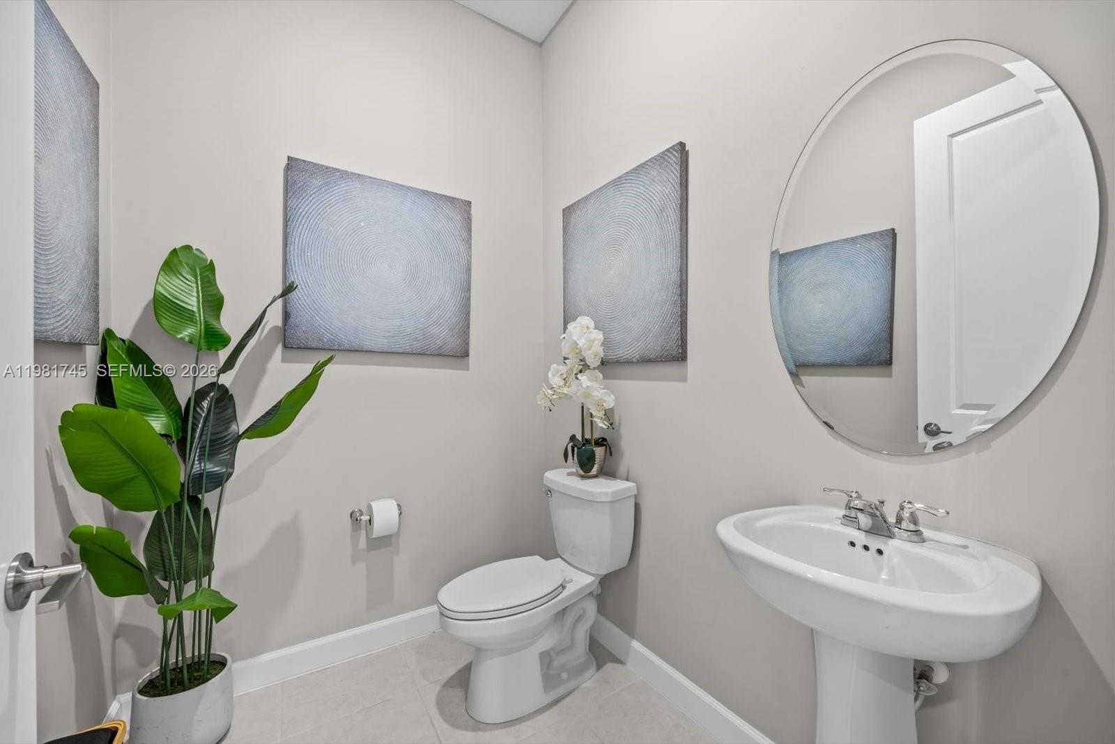 1204 Southeast Woodbine Road Port St. Lucie, FL 34984 - Photo 37 of 46 a bathroom with a toilet sink and mirror