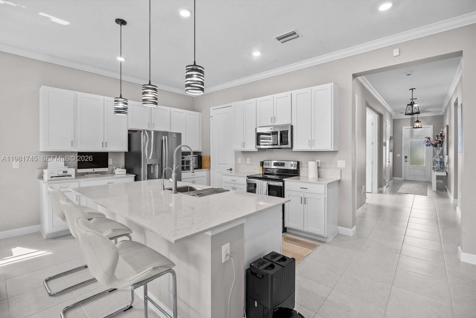 1204 Southeast Woodbine Road Port St. Lucie, FL 34984 - Photo 8 of 46 a kitchen with kitchen island a stove a table and chairs