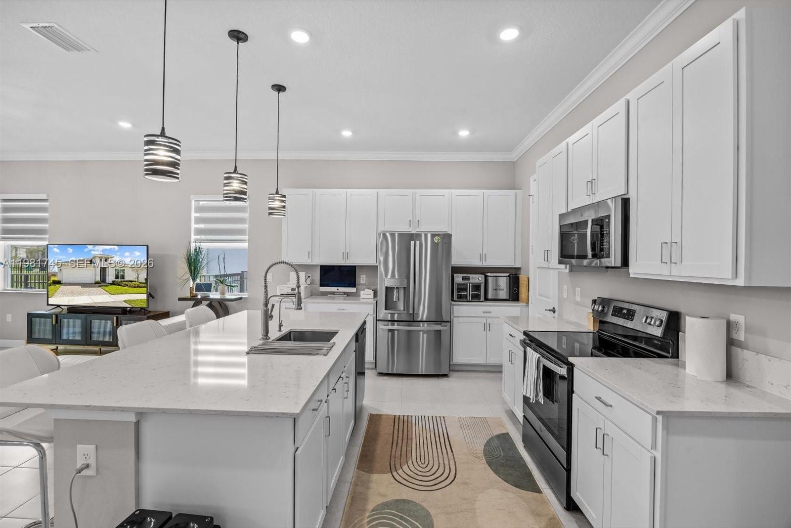 1204 Southeast Woodbine Road Port St. Lucie, FL 34984 - Photo 9 of 46 a kitchen with a sink a counter top space stainless steel appliances and cabinets