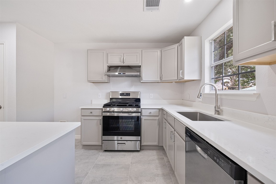 2101 Bridal Path Cedar Park, TX 78613 - Photo 11 of 38 a kitchen with stainless steel appliances granite countertop a sink stove and microwave