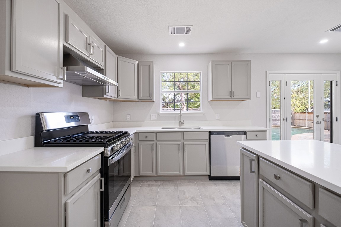 2101 Bridal Path Cedar Park, TX 78613 - Photo 12 of 38 a kitchen with stainless steel appliances granite countertop a sink stove and cabinets