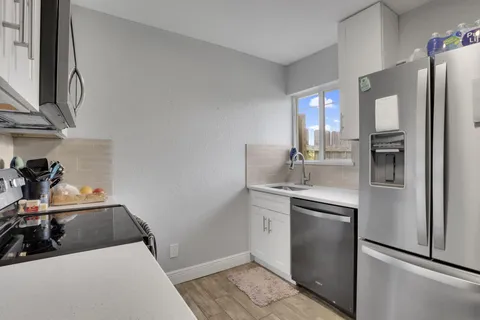 a kitchen with stainless steel appliances a sink stove and refrigerator