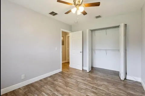 a view of an empty room with wooden floor