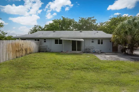 a backyard of a house with table and chairs
