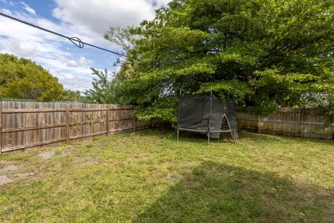 a backyard of a house with plants and tree