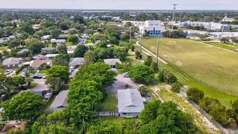 an aerial view of residential houses with outdoor space and swimming pool