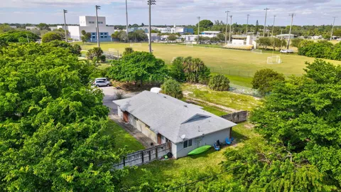 an aerial view of a house with a garden and lake view