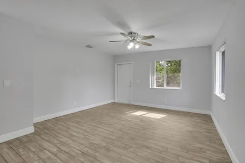 wooden floor in an empty room with a window
