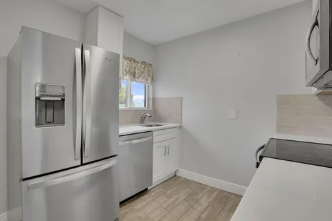 a kitchen with a refrigerator sink and cabinets