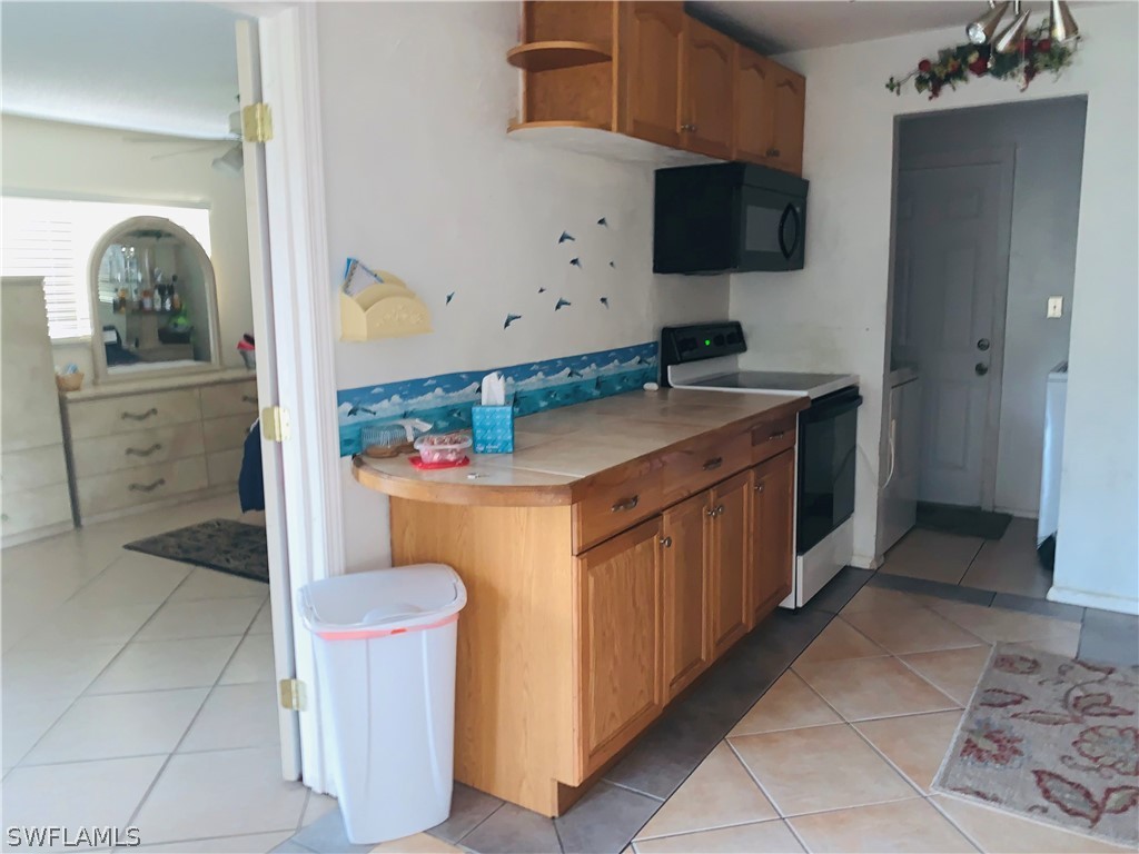 18189 Iris Road Fort Myers, FL 33967 - Photo 6 of 30 a kitchen with stainless steel appliances granite countertop a stove and a sink