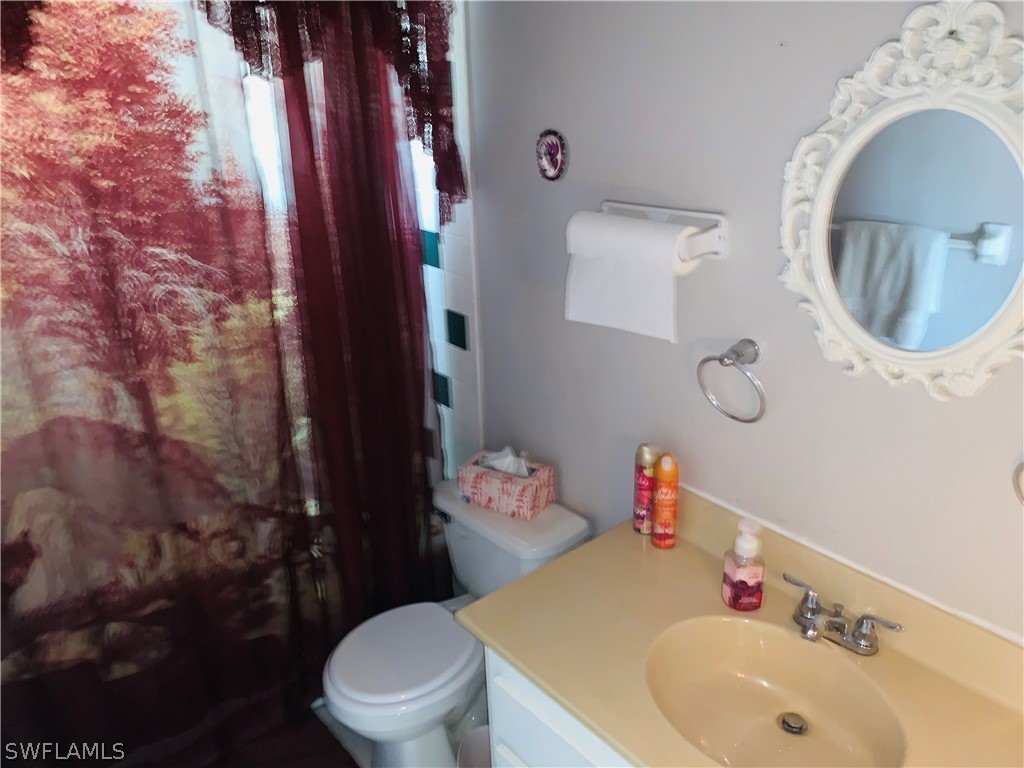 18189 Iris Road Fort Myers, FL 33967 - Photo 7 of 30 a bathroom with a sink a toilet and a mirror