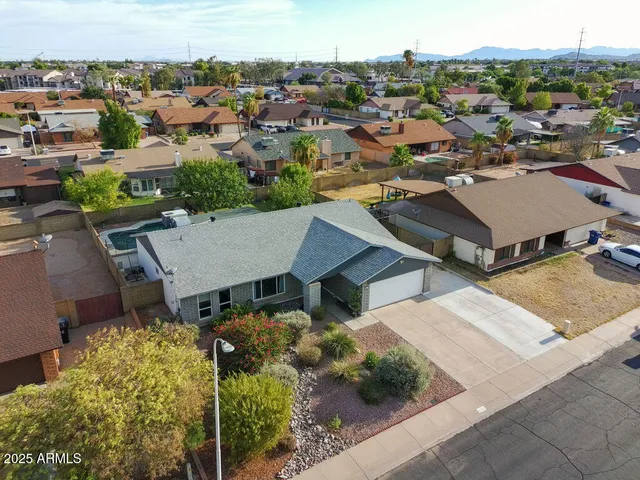an aerial view of a house with yard and mountain view in back