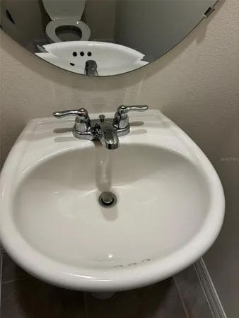 a bathroom with a sink and mirror with toilet