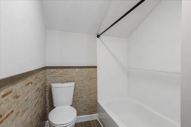 a white toilet sitting next to a bath tub