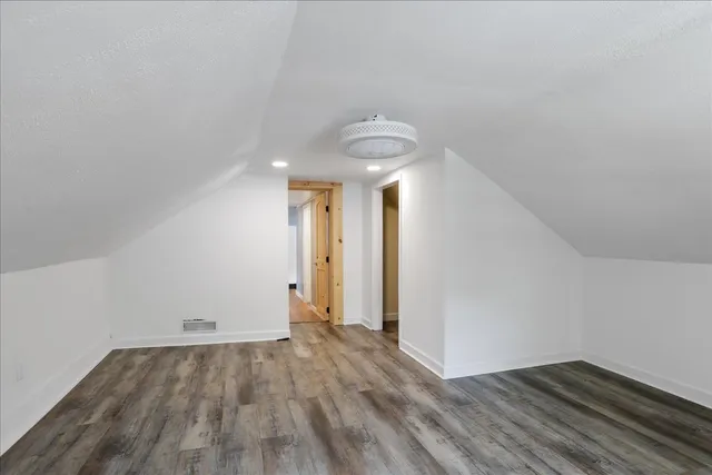 a view of a room with wooden floor and white walls