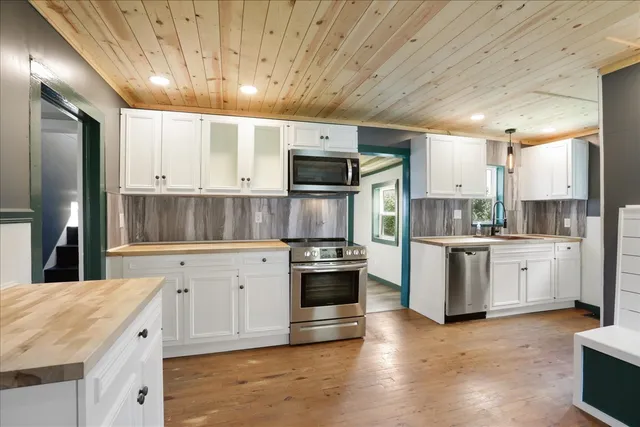 a kitchen with granite countertop white cabinets and stainless steel appliances