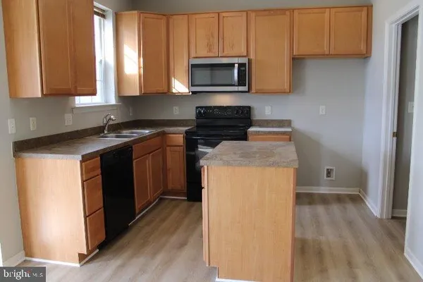 a kitchen with a stove microwave and sink