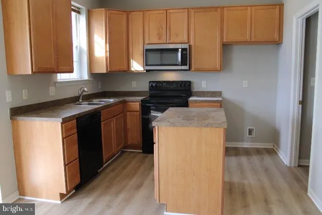a kitchen with a stove microwave and sink