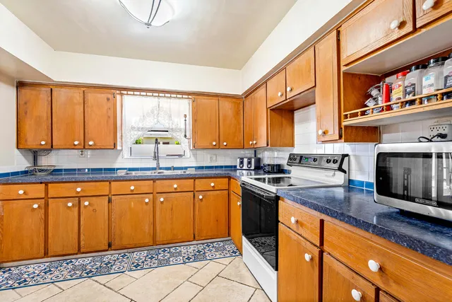 a kitchen with stainless steel appliances granite countertop a sink stove and cabinets