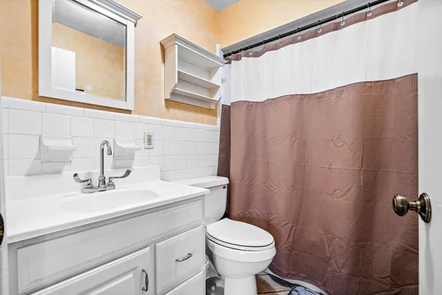 a bathroom with a sink a toilet and a mirror