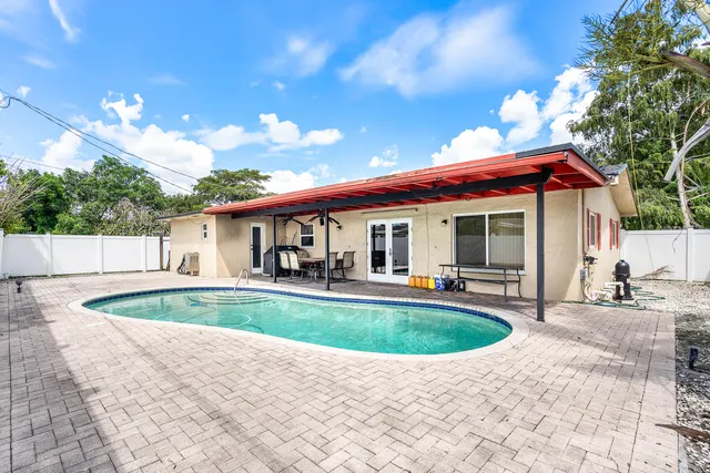 a view of a house with swimming pool and sitting area