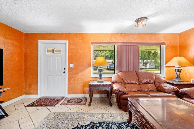 a living room with furniture a lamp next to a window
