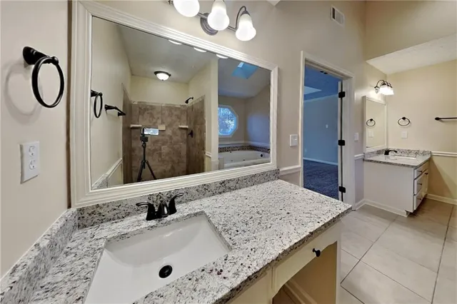 a bathroom with a granite countertop sink and a mirror