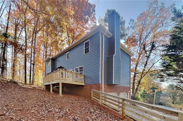 a view of a house with a yard and wooden fence