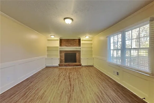 a view of an empty room with a fireplace and a window