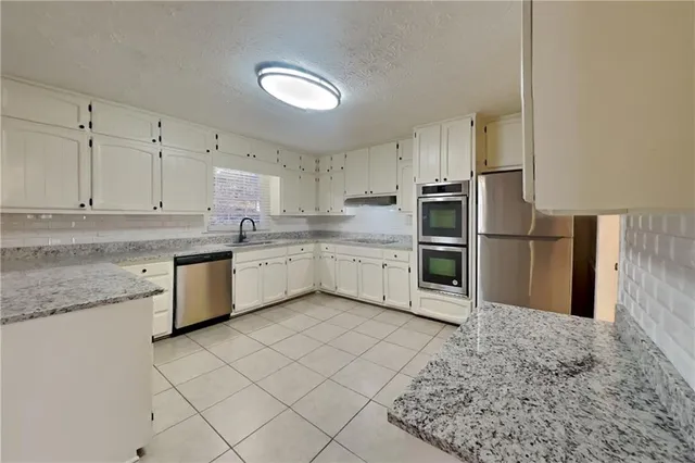 a kitchen with stainless steel appliances granite countertop a refrigerator sink and cabinets