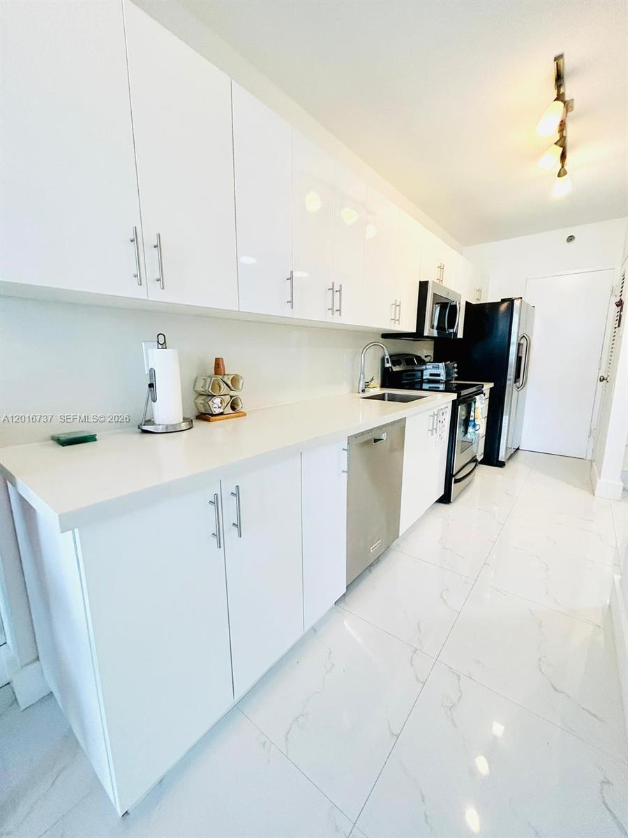 100 Lincoln Road, Unit 1526 Miami Beach, FL 33139 - Photo 5 of 9 a kitchen with stainless steel appliances granite countertop a sink and cabinets