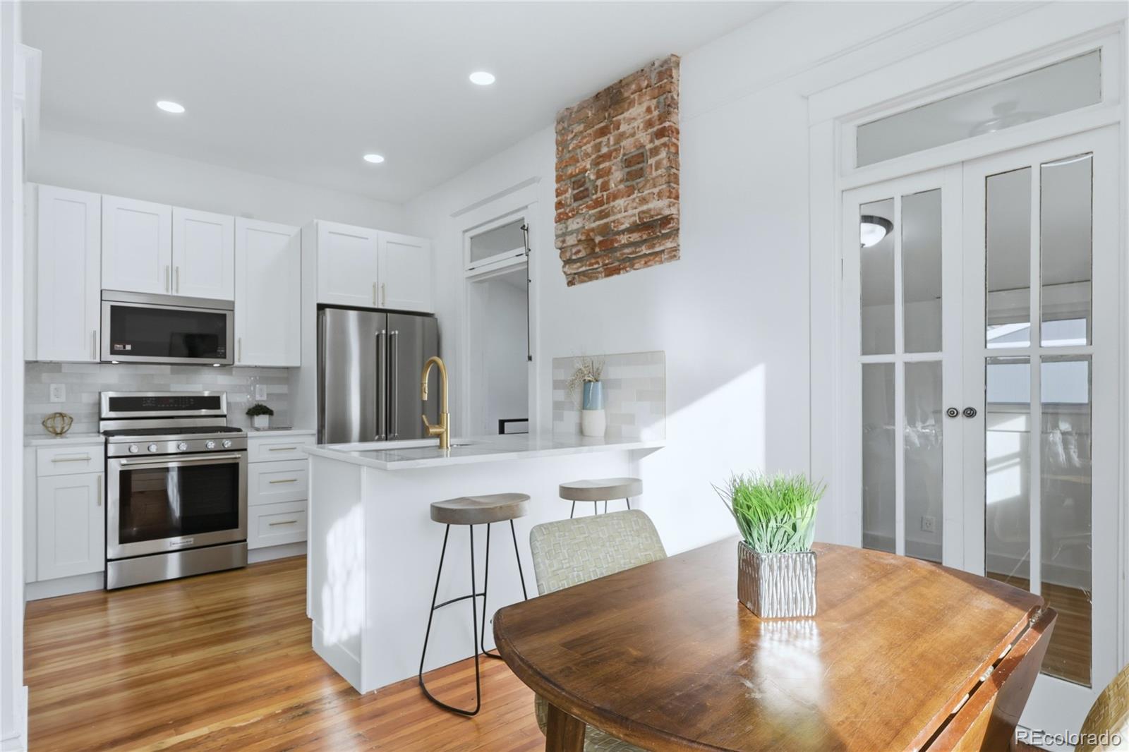 3051 West 37th Avenue Denver, CO 80211 - Photo 12 of 37 a kitchen with a table chairs refrigerator and microwave
