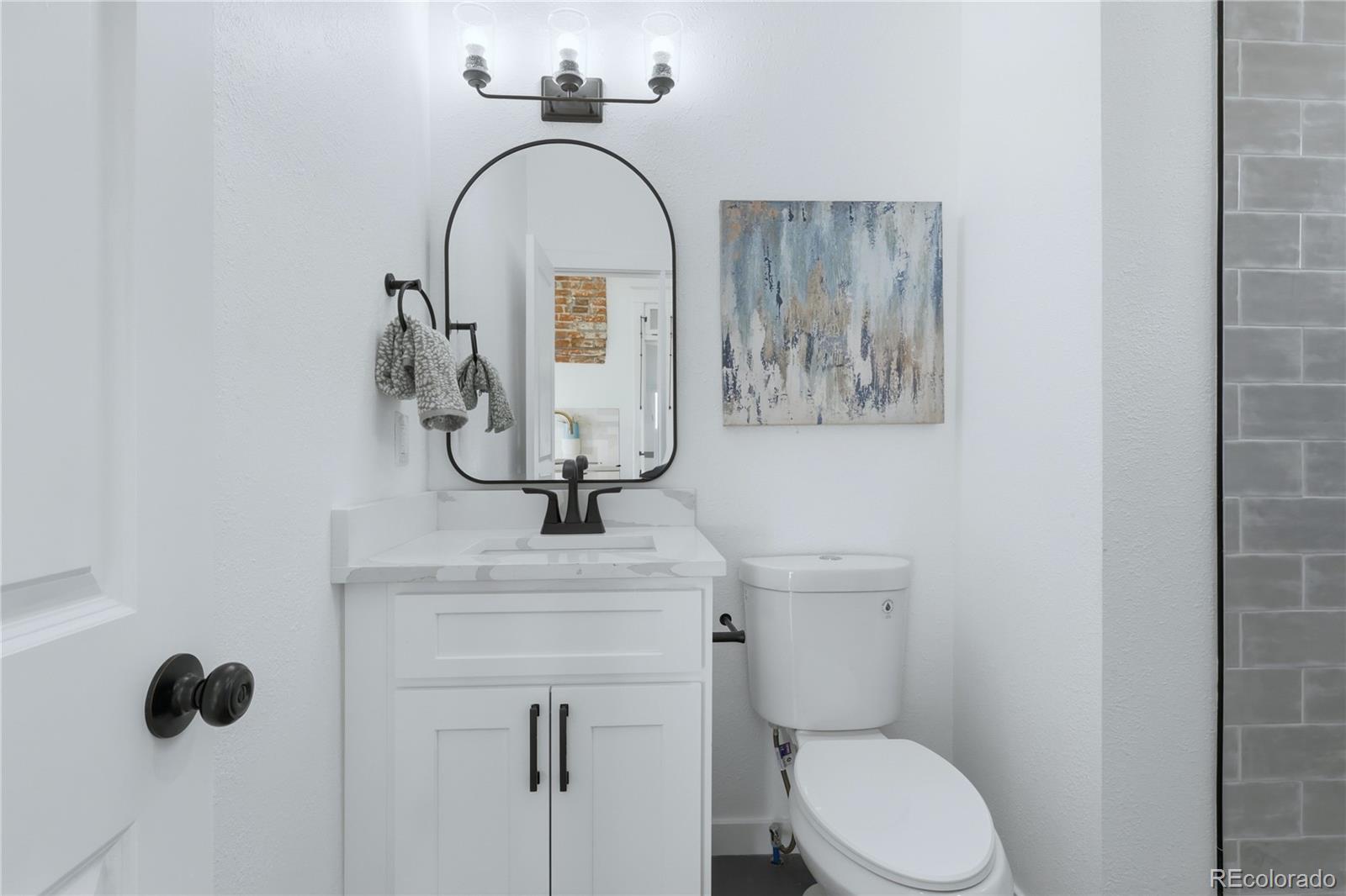 3051 West 37th Avenue Denver, CO 80211 - Photo 18 of 37 a bathroom with a toilet sink and mirror
