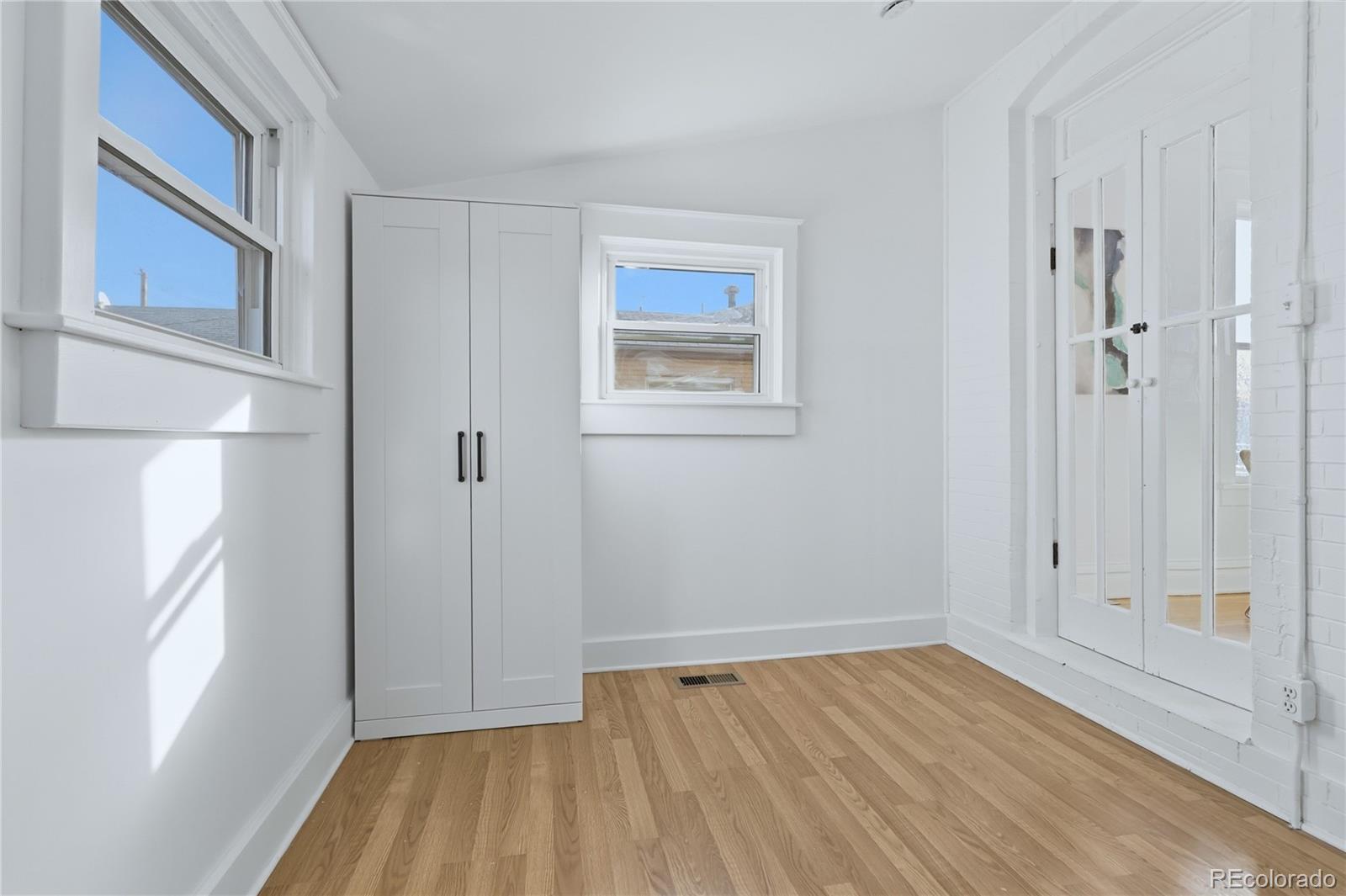 3051 West 37th Avenue Denver, CO 80211 - Photo 21 of 37 a view of an empty room with wooden floor and a window