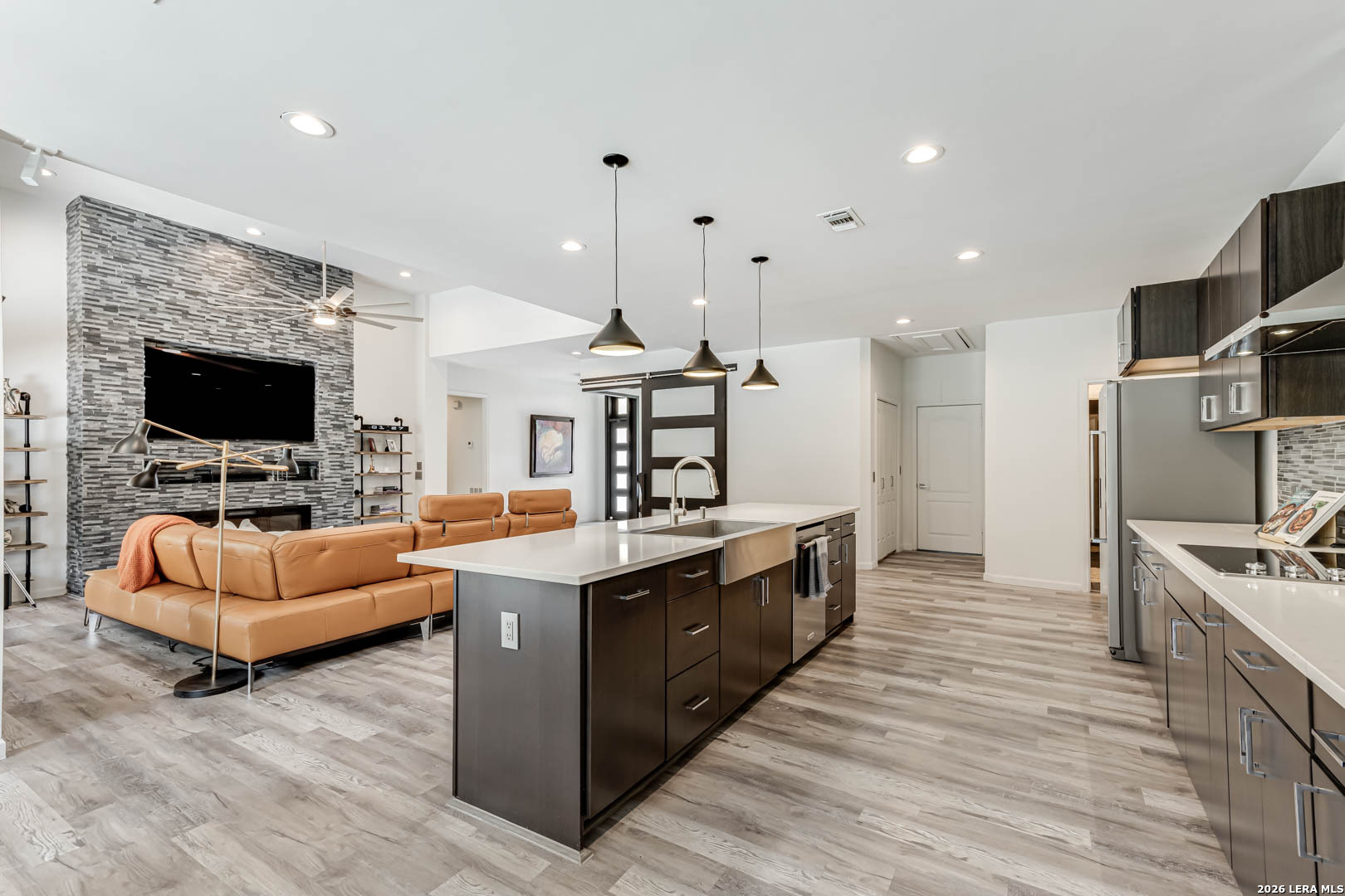 15919 Mission Ridge San Antonio, TX 78232 - Photo 21 of 43 a large kitchen with stainless steel appliances a stove a sink and a living room view